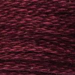 A close-up view of embroidery thread skeins, held taught horizontally. The shade is a dark red-purple, like a black cherry.