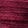 A close-up view of embroidery thread skeins, held taught horizontally. The shade is a jewel-like dark red, like burgundy wine.