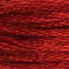 A close-up view of embroidery thread skeins, held taught horizontally. The shade is a very dark rusty red, tending slightly toward orange.