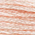 A close-up view of embroidery thread skeins, held taught horizontally. The shade is a very pale cream, like a fresh egg.