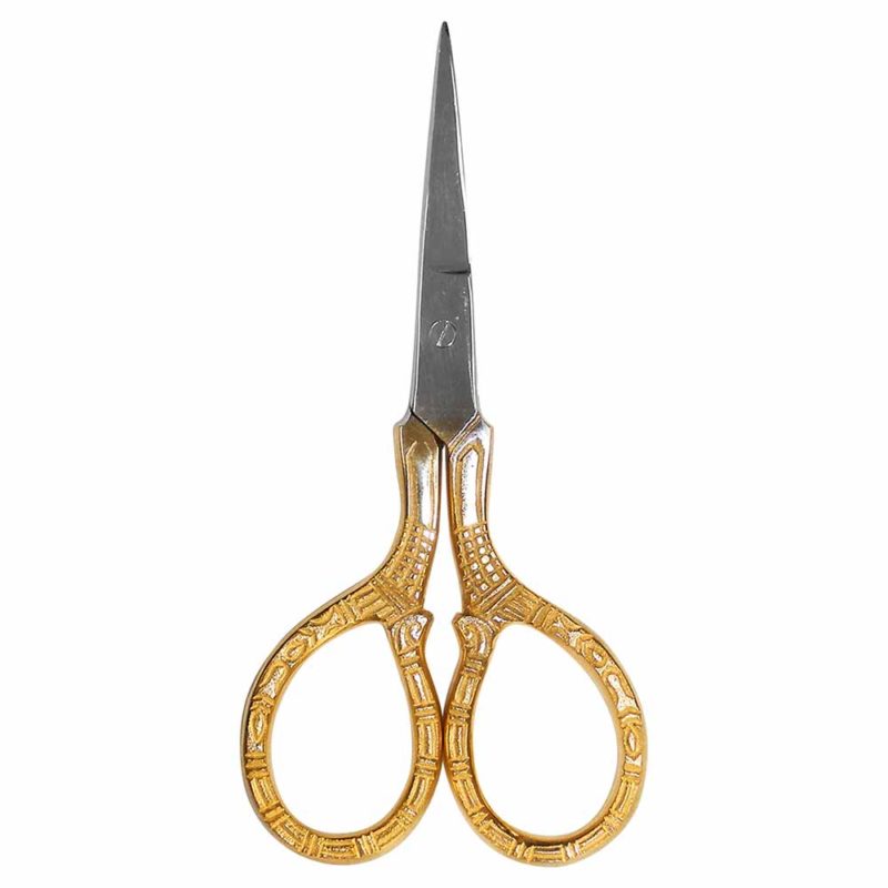 A pair of upside down scissors laying flat on a white background with golden ornate handles and pointed tips