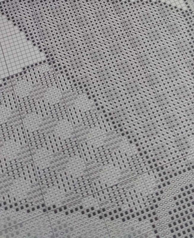 Close up of gridded cross stitch pattern in black and white