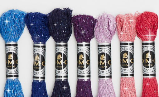 Several colours of sparkly floss with DMC wrappers visible