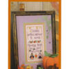 A finished cross stitch is framed beside a plastic pumpkin. Text reads, "Children gather dressed to scare, wanting treats, so just beware"
