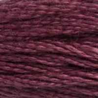 A close-up view of embroidery thread skeins, held taught horizontally. The shade is a deep red-purple plum colour, like grape jam.