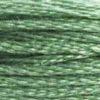 A close-up view of embroidery thread skeins, held taught horizontally. The shade is a medium light green that blends well with #319 Pistachio Green Very Dark