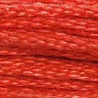 A close-up view of embroidery thread skeins, held taught horizontally. The shade is a medium shade of orangey pink, like the flesh of an over-ripe grapefruit.