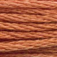 A close-up view of embroidery thread skeins, held taught horizontally. The shade is a medium dark brick orange, like cinnamon but not as red