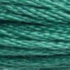 A close-up view of embroidery thread skeins, held taught horizontally. The shade is a medium blue-green