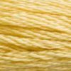 A close-up view of embroidery thread skeins, held taught horizontally. The shade is a light golden yellow with a touch of green