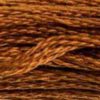 A close-up view of embroidery thread skeins, held taught horizontally. The shade is a rich medium dark shade of pure brown, like a rolled cinnamon stick.