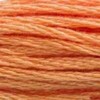 A close-up view of embroidery thread skeins, held taught horizontally. The shade is a pretty shade of orangey pink like salmon out of a can.