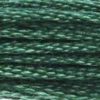 A close-up view of embroidery thread skeins, held taught horizontally. The shade is a medium dark beautiful green with just a hint of blue, like a pine tree in winter
