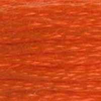A close-up view of embroidery thread skeins, held taught horizontally. The shade is a pretty medium orange with slight brick red undertones, just the colour of pumpkin candy