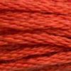A close-up view of embroidery thread skeins, held taught horizontally. The shade is a lovely dark orange with just a hint of brick red