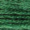 A close-up view of embroidery thread skeins, held taught horizontally. The shade is a beautiful medium dark jewel green, like a jungle snake among vines