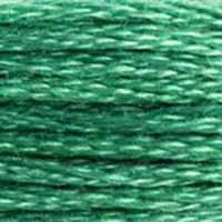 A close-up view of embroidery thread skeins, held taught horizontally. The shade is a beautiful light true green, like an emerald in sunlight