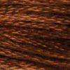 A close-up view of embroidery thread skeins, held taught horizontally. The shade is a medium dark brown with a golden touch, like a light-roast coffee bean