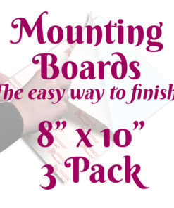 A white square with a faint image of a person's hands using a mounting board. Text in front of it reads, "Mounting Boards, The easy way to finish! 8 inches by 10 inches 3-pack"